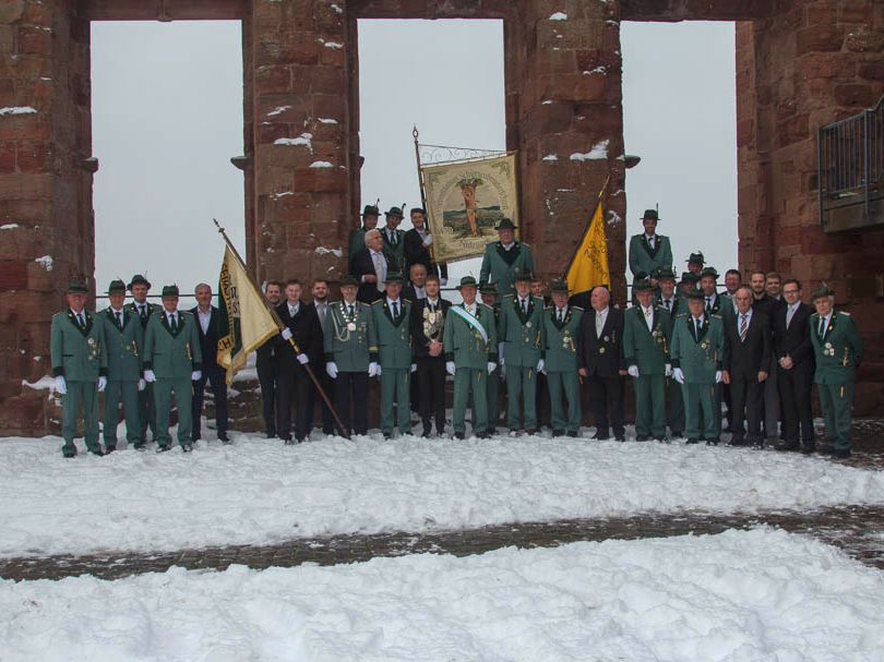 Gruppenbild der St. Sebastianus Schützenbruderschaft am Patronatsfest im schneebedeckten Burghof 2023.